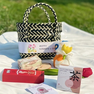 Detail showing handwoven basket with Happy Women's Day ribbon and floral gift set