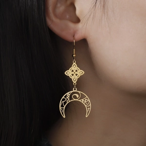 Golden Celtic knot and crescent moon tassel earrings worn by model for elegant display