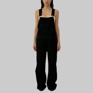 Detailed view of women's loose casual black denim overalls with functional side pockets