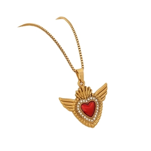 Gold winged heart necklace with red center and white zircon stones on white background