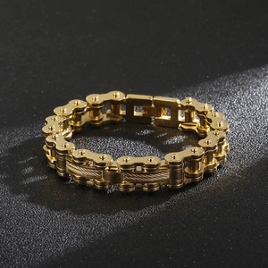 Detail of golden stainless steel bicycle chain bracelet with steel wire texture