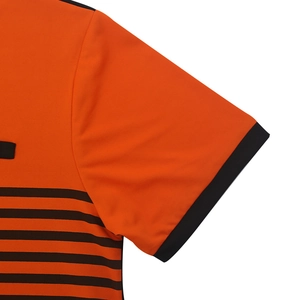 Gros plan sur la manche d'un polo orange à rayures noires et texture en tissu respirant