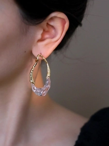 Détail de la boucle d'oreille en résine plaquée or 18k avec un design ovale évidé