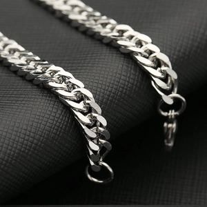 Polished silver stainless steel Cuban link bracelet with spring clasp on black background