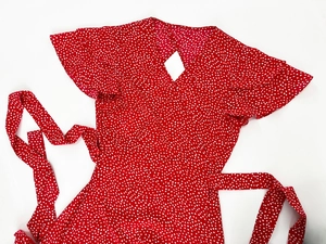 Detailed view of red polka dot dress with ruffle sleeves and waist tie fastening