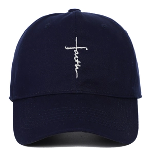 Close-up of the white Faith cross embroidery on the navy blue cotton baseball cap