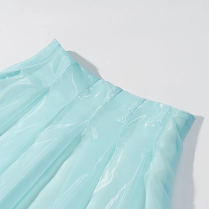Vue macro détaillée de la texture du tissu organza plissé bleu clair à la taille de la jupe