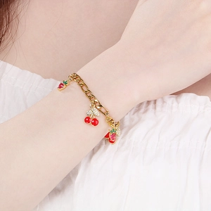 Gold chain bracelet featuring cherry and strawberry charms with red enamel and zircon stones
