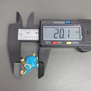 Detailed view of blue enamel elephant pendant being measured with digital calipers at 20.1 mm