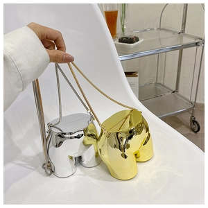 Detailed view of mirrored gold and silver torso-shaped crossbody bags with chain straps
