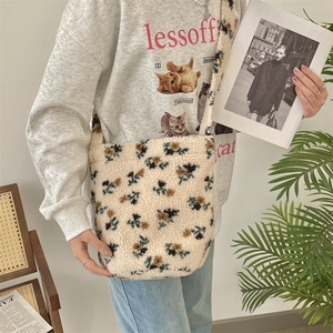 Close-up of plush floral shoulder bag showing soft fleece texture and wide strap