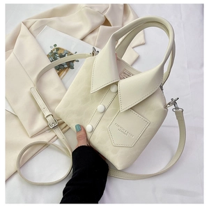 Detail of creative shirt-shaped tote bag in cream white with buttons and collar