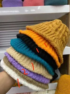Detailweergave van diverse gekleurde gebreide vissershoeden voor dames.