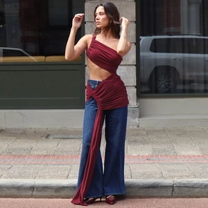 Détail du haut bordeaux à une épaule et du jean large bleu foncé pour femmes chic