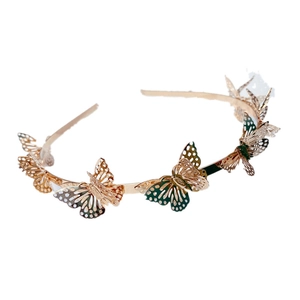 Detailed macro view of the 3D hollow butterfly decorations on a gold metal headband