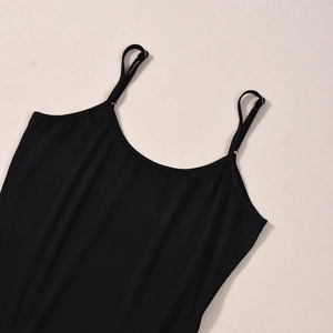 Détail d'un caraco noir minimaliste à fines bretelles spaghetti en tissu doux et souple