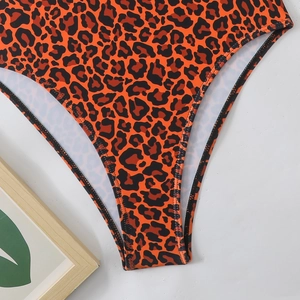 Detailed close-up of leopard print swimsuit fabric featuring high-elasticity orange stitching