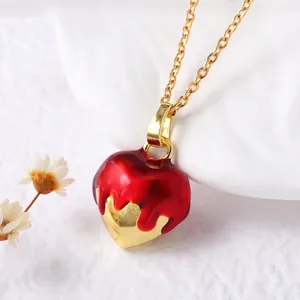 Artistic gold-plated heart pendant necklace with red dripping oil effect on white background