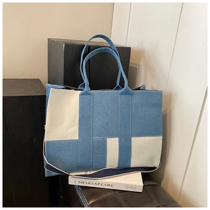 Detail shot of multi-color denim tote bag with contrast stitching and sturdy handles