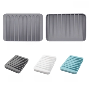 Detail of rectangular silicone soap holders with drainage slots in gray, white, and teal colors