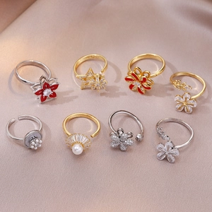 Elegant gold and silver open rings with red enamel flowers and pearls on silk
