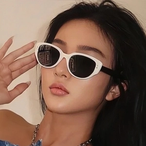 Close-up of stylish white cat-eye sunglasses with black lenses worn by a model