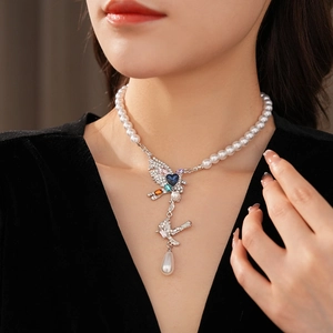 Gros plan du collier vintage oiseau et cœur avec perles et strass colorés