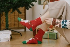 Close-up of thick coral fleece Christmas socks with Santa and reindeer embroidery