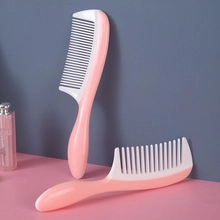 Macro detail of the pink and white plastic anti-static detangling hair comb set