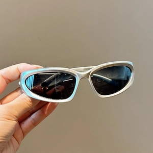 Détail de lunettes de soleil sport argentées avec verres noirs au style mode Y2K