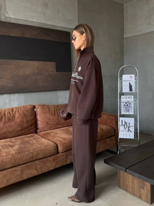 Detail of a brown half-zip sweatshirt and wide-leg trousers set with contrast printing