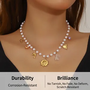 Dettaglio della collana di perle vintage con ciondoli a forma di delfino e sole