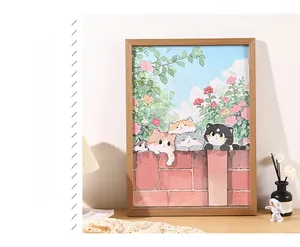 Detail of a natural wood frame holding a cute cat illustration on a wooden desktop