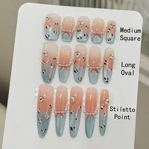 Unghie finte sfumate blu e rosa con effetto occhio di gatto, fiocchi e perle