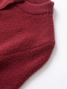 Detailed macro view of plush burgundy knit fabric and ribbed collar craftsmanship