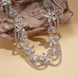 Macro detail of silver layered fringe necklace with crystal floral motifs and sparkling rhinestones