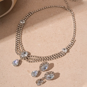 Vue à plat de l'ensemble collier à trois couches en zircon et boucles d'oreilles