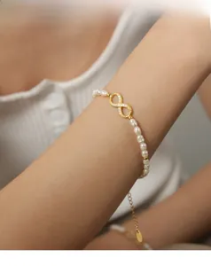 Macro shot of freshwater pearl bracelet with gold infinity charm and zircon accents
