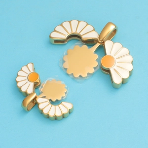 Detail of gold sunflower charm with white enamel petals and protective film for DIY jewelry