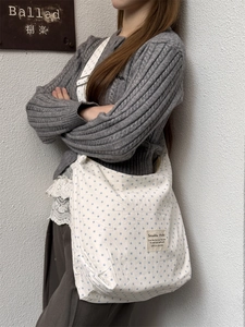 Detail of white canvas tote bag with blue star print and vintage brand patch label