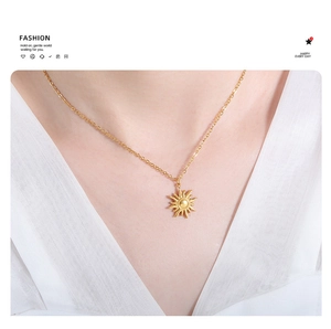 Detail of 18K gold-plated sun pendant necklace worn on neck with radiant rays design