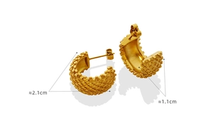 Macro detail of gold-plated C-shaped earrings with textured pattern and size markings