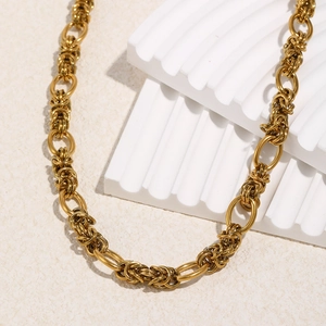 Detailed close-up of 18K gold plated stainless steel interlinked rings on a textured base