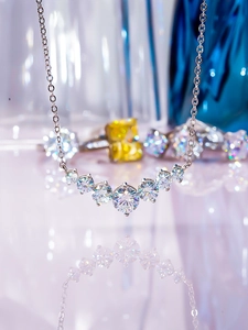 Detail of 925 sterling silver necklace featuring seven graduated moissanite stones in a smile arc
