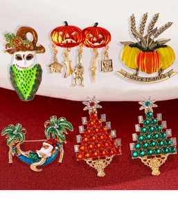 Macro shot of 6pcs festive enamel brooches and earrings on red velvet background