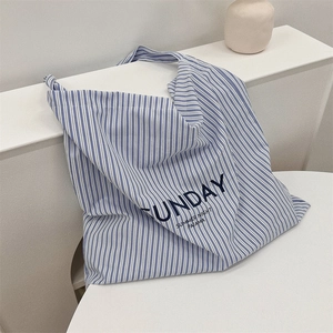 Detail of blue and white striped canvas tote bag with Sunday Summer Night text print