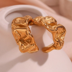Macro shot of 18K gold plated ring with irregular lava texture and pleated metal detail