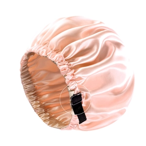 Detail of pink satin sleep cap featuring an adjustable black buckle for custom fit