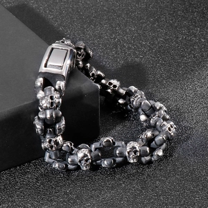 Detailed close-up of retro stainless steel skull bracelet on dark textured background