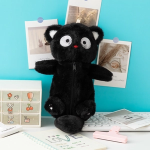 Gros plan d'une trousse chat noire en peluche avec de grands yeux et un nez rouge